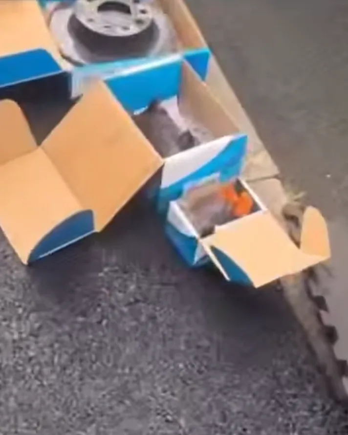 A brake disc and opened pad boxes on the tarmac at a Road Runner job
